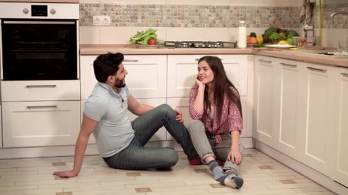 Couple Laughing and Talking Together in a Kitchen