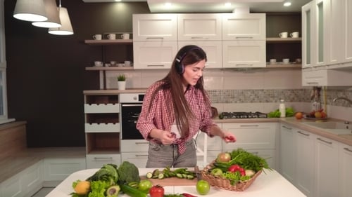Woman Dancing and Preparing Vegetables in Kitchen