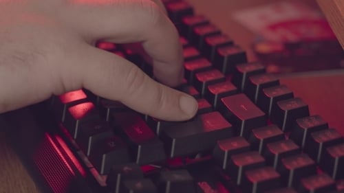 Cyberkriminalität, die Hände eines Mannes, der etwas auf den Schlüsseln gewinnt.