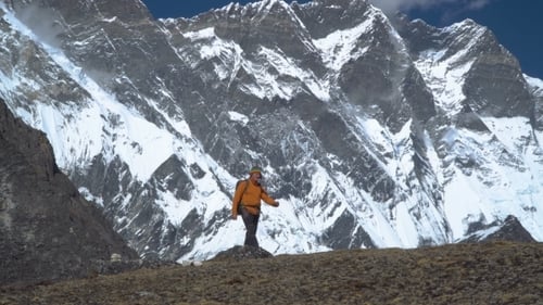 Man with Backpack Climb the Mountain Slope in the Himalayas