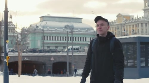 Man Walking on Urban Street in Modern City at Winter Day