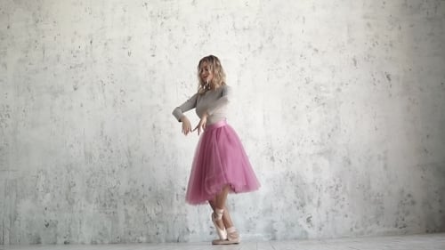 Young Ballerina Is Dancing a Classical Ballet. Ballet Dancer in a Pink Tutu and Golden Pointes