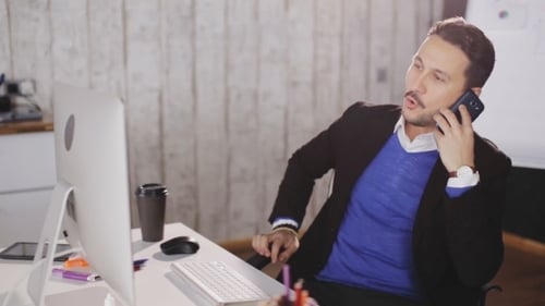 Man Talking on the Phone in a Modern Office