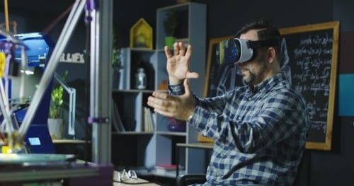 Man Uses VR Headset Next to a 3D Printer