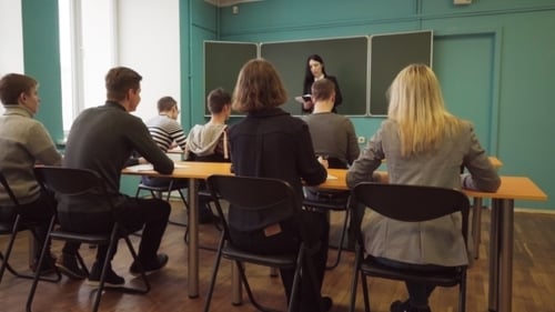 Students in Classroom with Teacher Giving Lesson