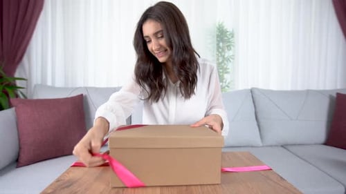 Woman Unpacks Present with Ceramic Gifts at Home