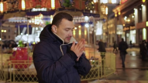 Man Warming Hands on Cold Winter Night