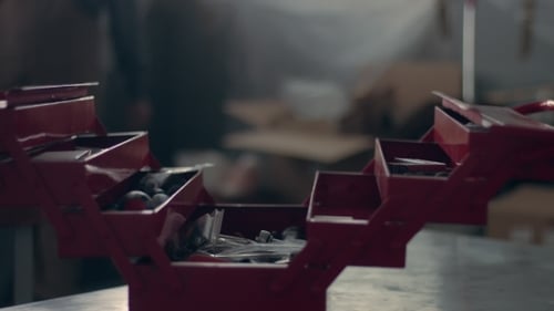 Worker in His Garage with a Red Tool Storage Box