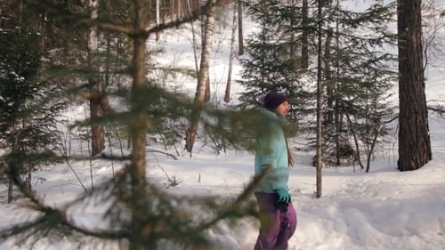 A Young Woman Walks Through the Winter Forest and Photographs Nature