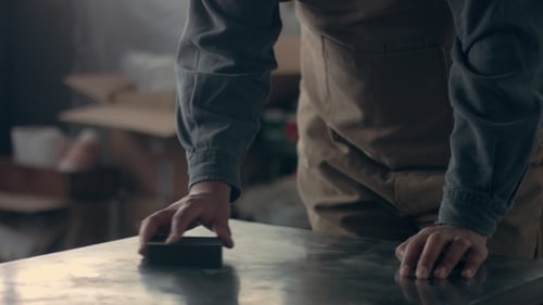 Man Sanding a Metal Table