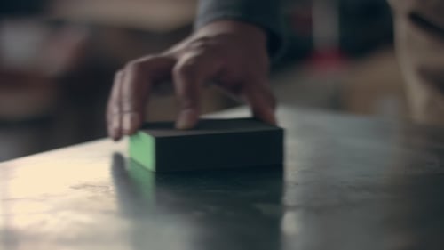 Man Sanding a Metal Table