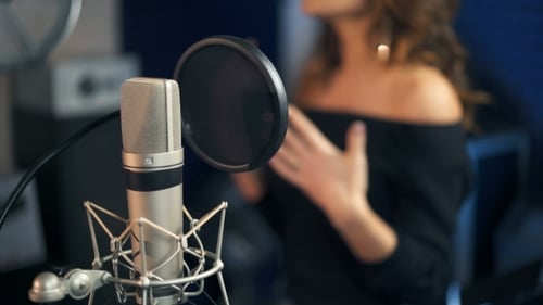 Professional Microphone in the Recording Studio Background of a Singing Woman