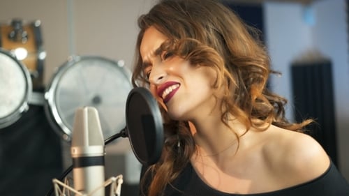 Young Female Singer Recording Album in the Professional Studio. Woman Singing a Song in Music