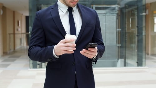 Young Adult Man with Coffee Using Phone