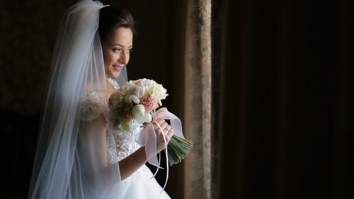 Beautiful Bride Holding Bouquet Posing By Window