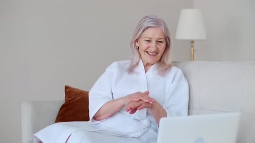 Woman Applies Lotion To Hands At Home