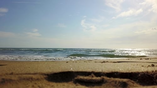 Under the Blue Sky the Waves Roll in on the Beach