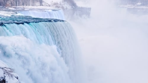 Magnificent Niagara Falls in Winter. Streams of Water Fall Down Against the Background of a Snow