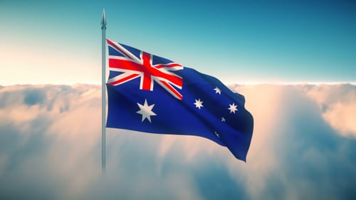 Waving Australian Flag Against Cloudy Sky Background