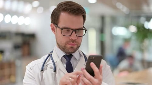 Male Doctor Using Smartphone in Modern Hospital