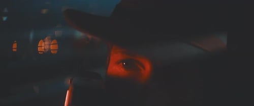 Close up of man through shutters and red lights using vintage camera