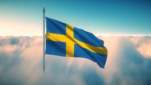 Waving Swedish Flag Against a Cloudy Blue Sky