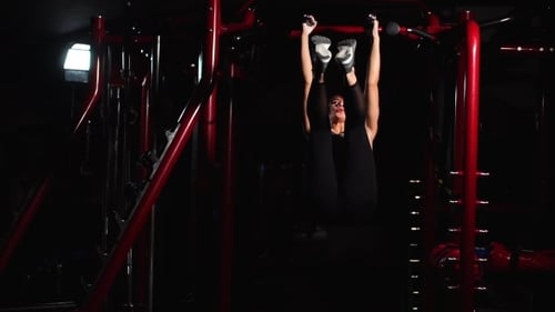 Fitness Woman effectuant des exercices de levée de jambes suspendues - L'un des exercices abdominaux les plus efficaces