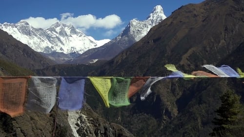 Banderas de oración tibetanas contra el pico blanco nevado de la montaña en la región del Everest de las montañas del Himalaya