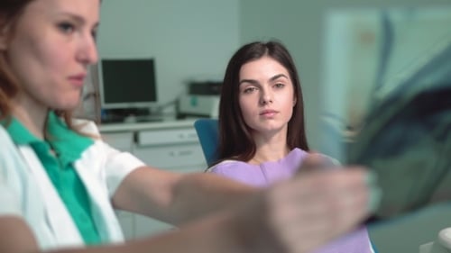 Female Dentist Shows X-ray
