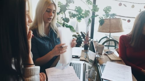 a Company Businesswomen Actively Discusses a Business Project in a Cafe and Signs a Contract