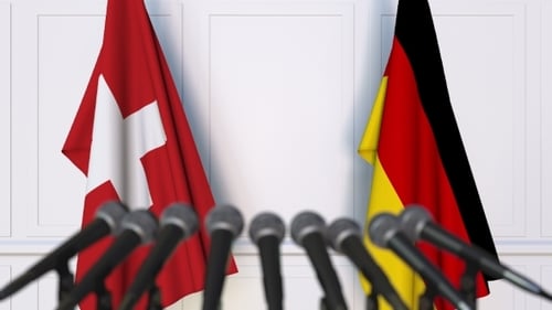 Waving Swiss and German Flags with Microphones for Corporate Presentation