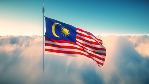 Malaysian Flag Waving Above Clouds
