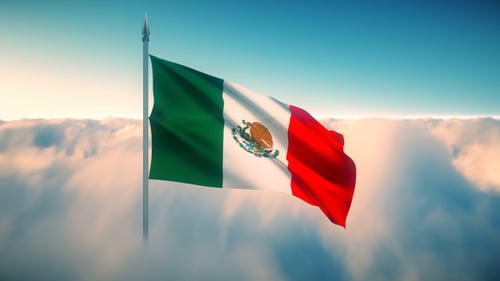 Realistic Mexican Flag Waving Over Clouds in Blue Sky Loop