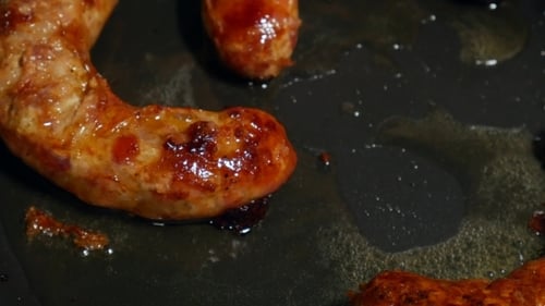 Overhead Frying Link Sausage Fast Food in Cast Iron Skillet