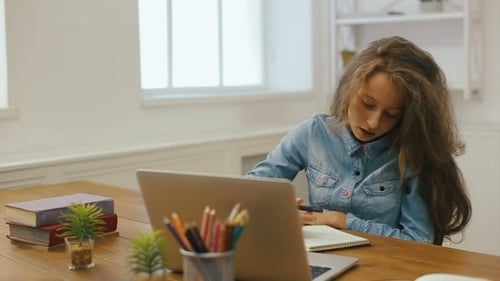 Jovem com computador portátil está fazendo lição de casa