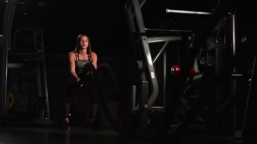 Female Athlete Working Out with Heavy Ropes at the Gym