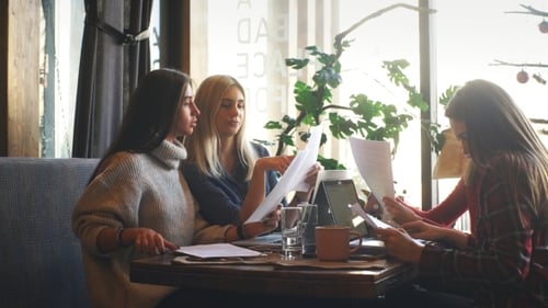 Company Businessman Discussing Documents Sitting in a Cafe