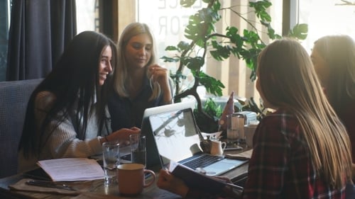 Beautiful Businesswoman Discussing Documents in a Cafe Over a Cup of Coffee