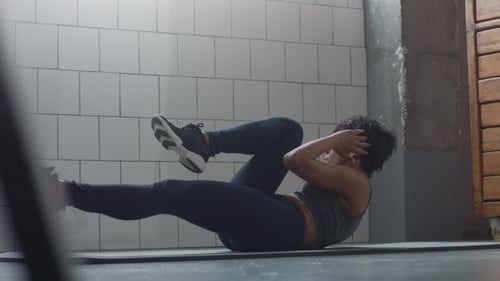 Side View Dolly Video of Black Woman Makes an Abs Routin on the Floor i Synny Loft