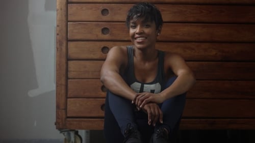 Young Fit and Tone Up Woman Sits Lean on Wooden Wardrobe During Workout Rest