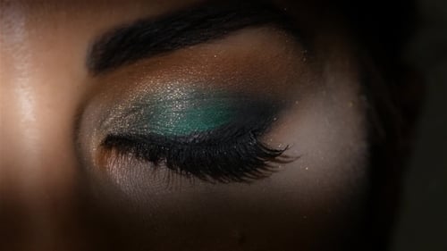 Fille avec un maquillage de soirée ouvre et ferme les yeux