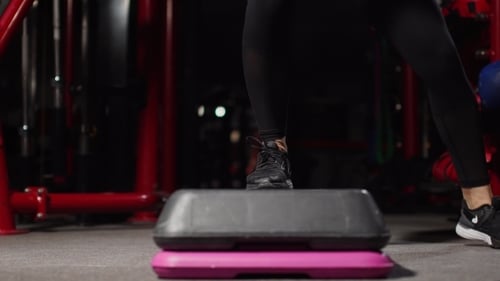 Woman Doing Step Aerobics in Gym