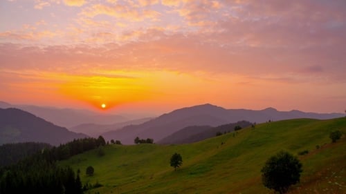 Majestic Mountain Sunrise Over Rolling Green Hills