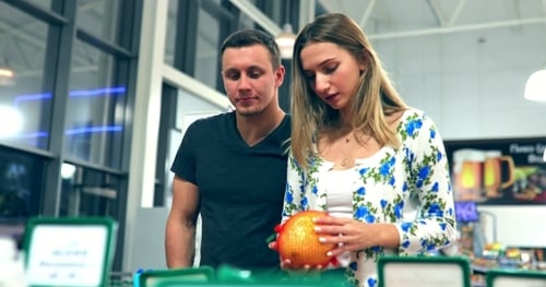Guy and Girl Near the Counter of Fruit in the Store / Couple in the Supermarket / Young Couple