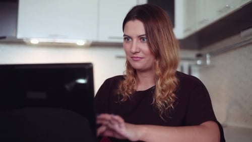 Woman Uses Laptop in Bright Kitchen