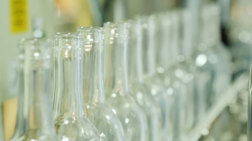 Glass Bottles Moving Along Conveyor Belt in Factory