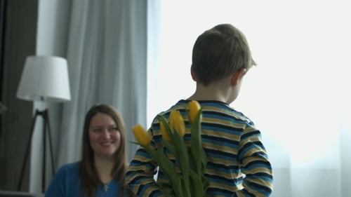 Niño sorprende a madre con flores en casa