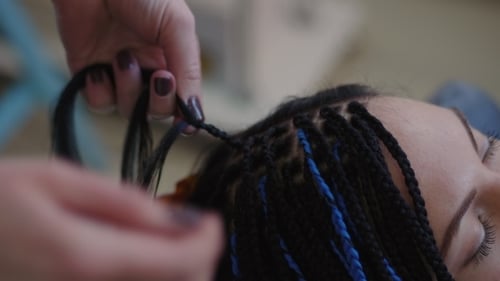 Proceso de tejido de trenzas africanas con Kanekalon. Trenzas africanas pequeñas con hebras artificiales azules