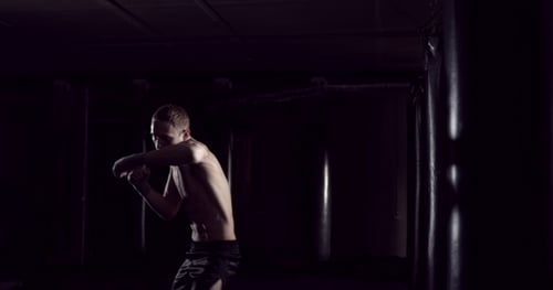 Kickboxer Shadow Boxing As Exercise for the Fight Fighter Training Punching Boxing in the Darknes
