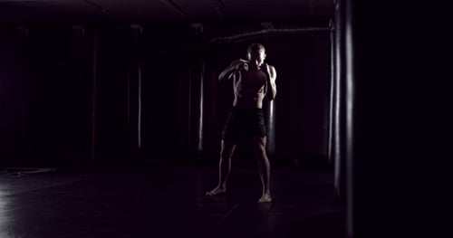 Kickboxer Shadow Boxing As Exercise for the Fight Fighter Training Punching Boxing in the Darknes